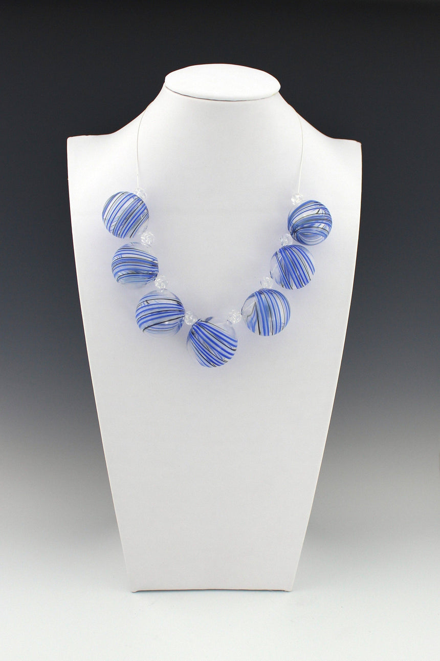 Blue, White and Black Stripes on Clear Hollow Beads, Carved Crystal Bead Spacers on silver filled wire and a matching silver toggle clasp.