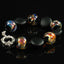 Five round  handmade lampwork glass beads are made with a base of black glass, covered in silver and then a silver based glass which creates a rainbow of colors from blue/green and red/gold swirls.  These beads are spaced with matt black obsidian lentil beads.  Black Onyx spacer beads complete the ensemble with a hefty silver clasp.